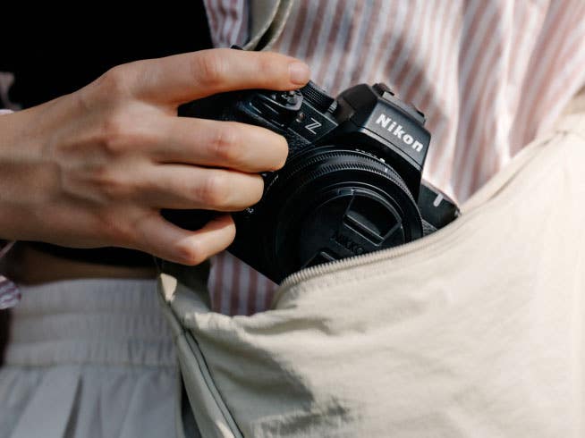 Photographer taking the Nikon Z50II Mirrorless camera from their bag. | Nikon Cameras, Lenses & Accessories