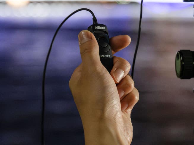 Hand holding the MC-DC3 Remote Cord connected to the Nikon Z50II Mirrorless Camera. | Nikon Cameras, Lenses & Accessories